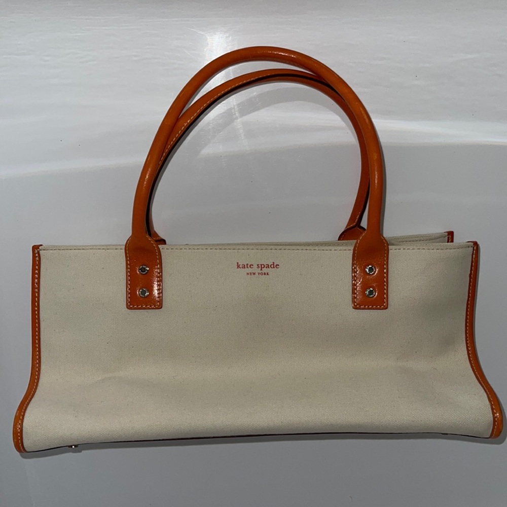Kate Spade cream cloth bag with orange leather straps.